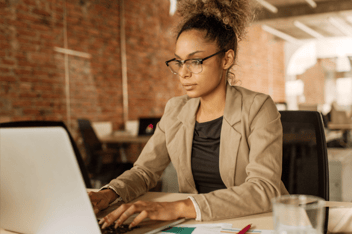 Woman working on laptop at office desk