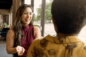 Two women having a discussion in a cafe. 