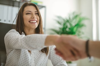 Woman shakes hands with interviewer.