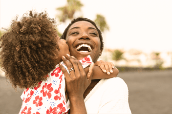 Mom hugging young daughter outdoors