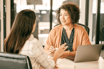 Two women speaking in a meeting