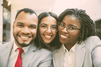 Three smiling coworkers taking a selfie