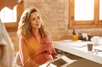 Pregnant woman sitting at office desk