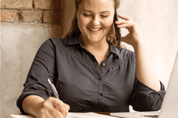 Woman on mobile phone taking notes