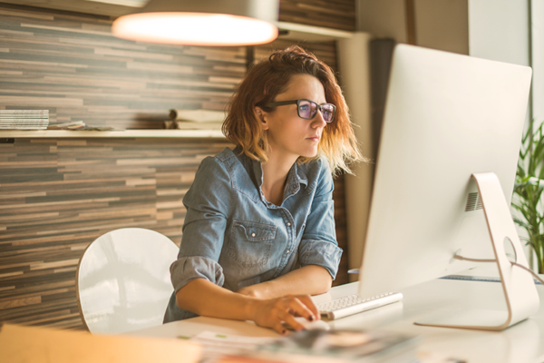 Woman sits at her home office desk