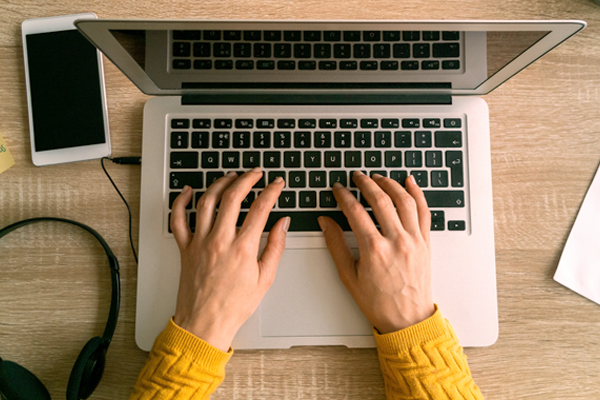 Woman typing on keyboard laptop