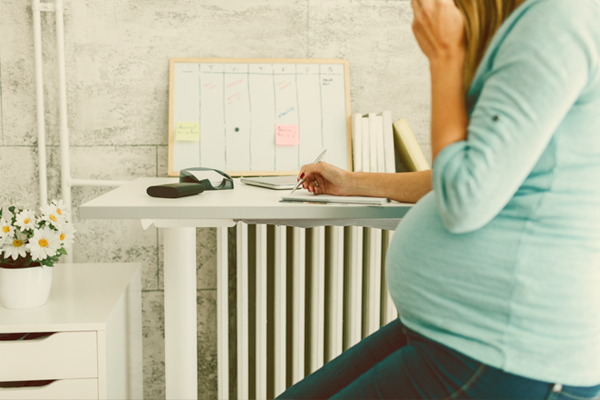 Pregnant woman sitting at office desk