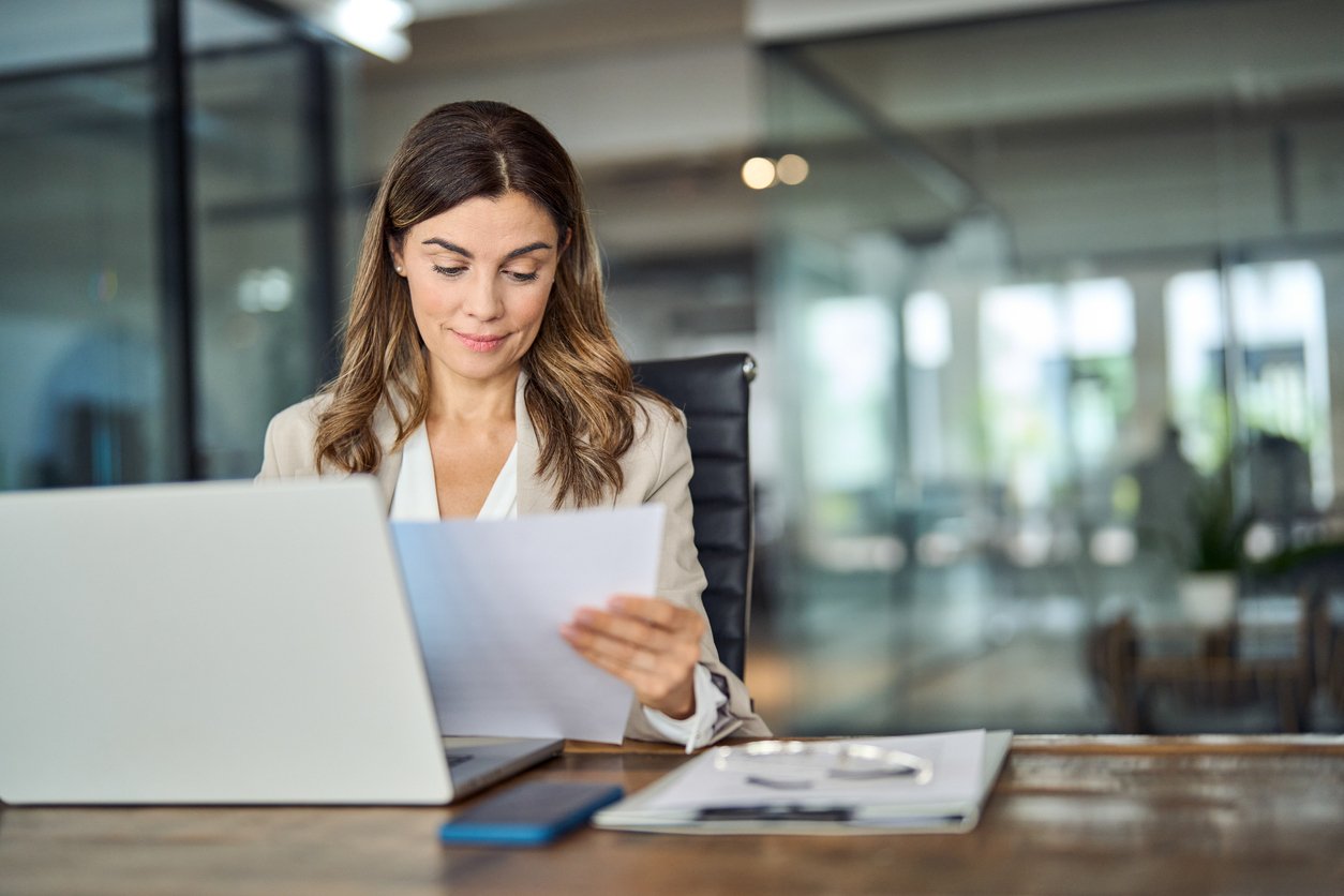 lady reading documents in front of laptop